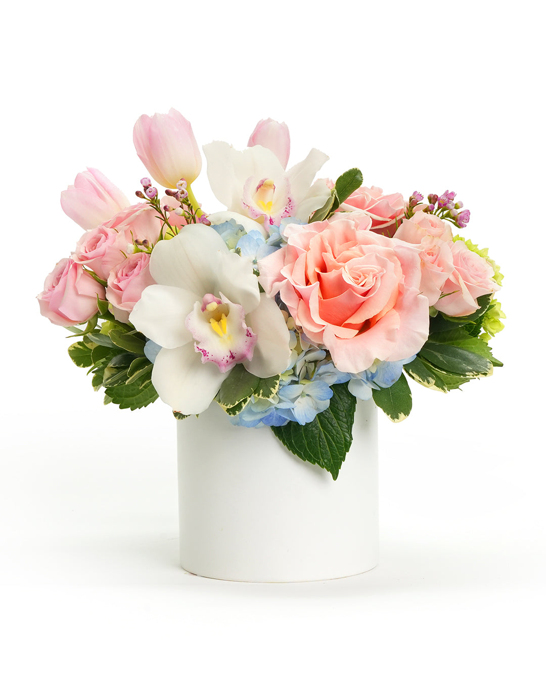 A delicate arrangement of pink roses, tulips, and orchids in a sleek white vase for any special occasion.