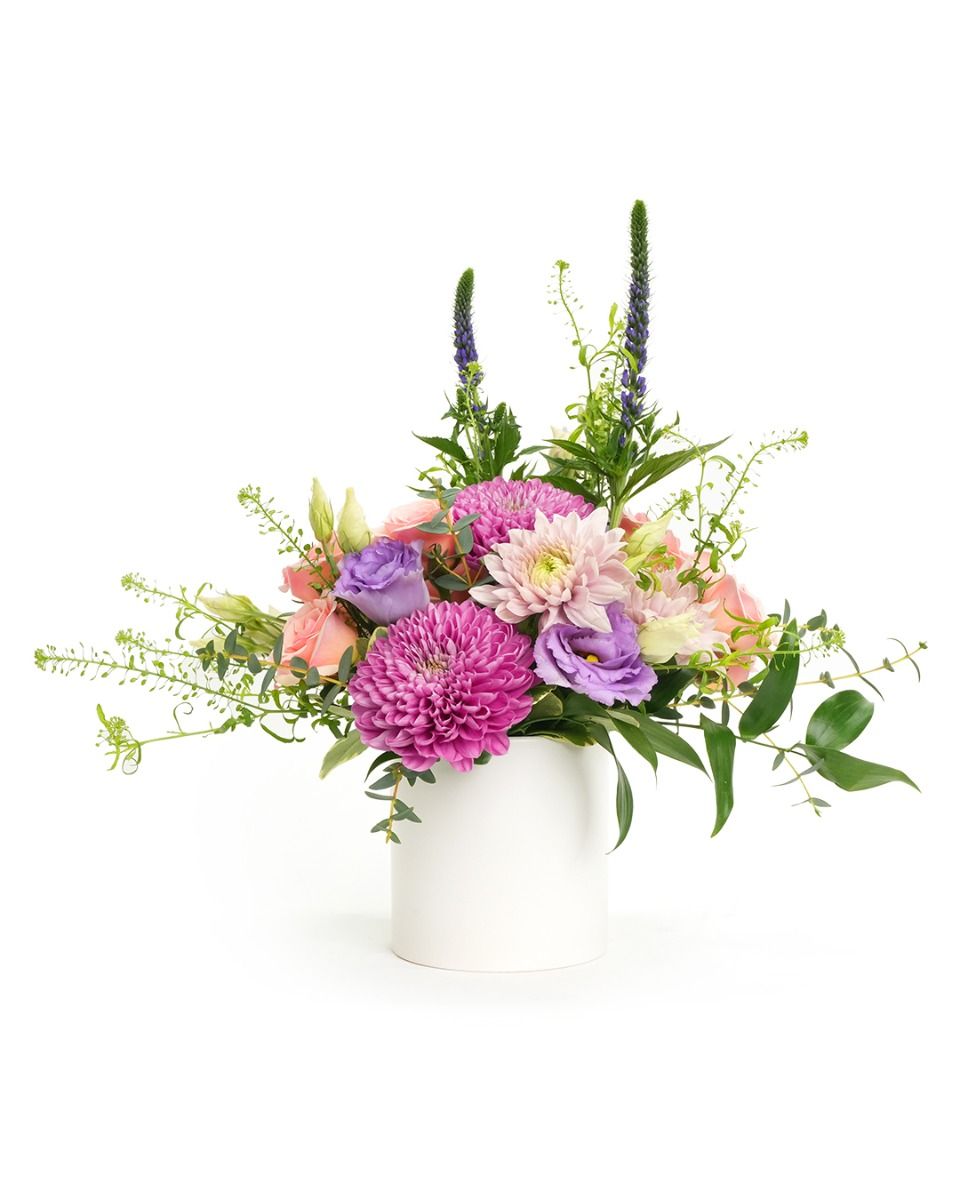 Vibrant flower arrangement with pink and purple blooms in a modern white vase, perfect for any occasion.