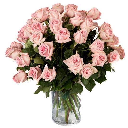 A stunning bouquet of soft pink roses arranged elegantly in a clear glass vase.