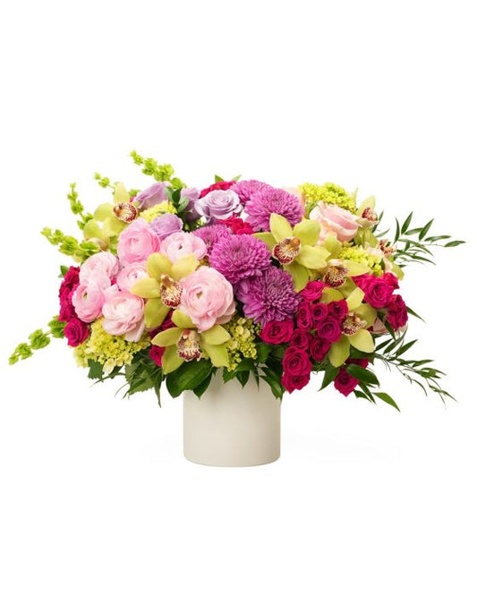 Vibrant floral arrangement featuring roses, orchids, and chrysanthemums in a sleek white vase.