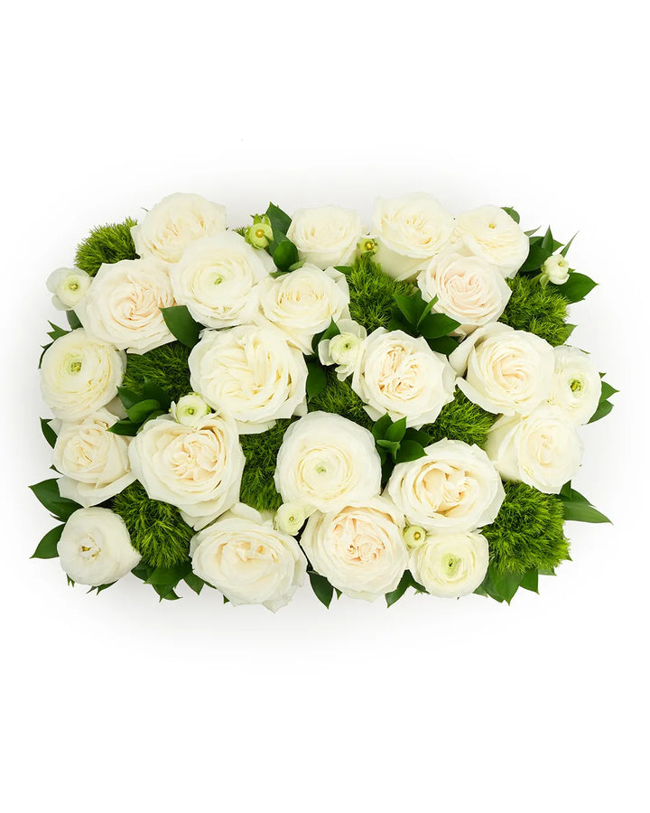 Elegant white ranunculus arranged with lush greens, perfect for weddings and special occasions.