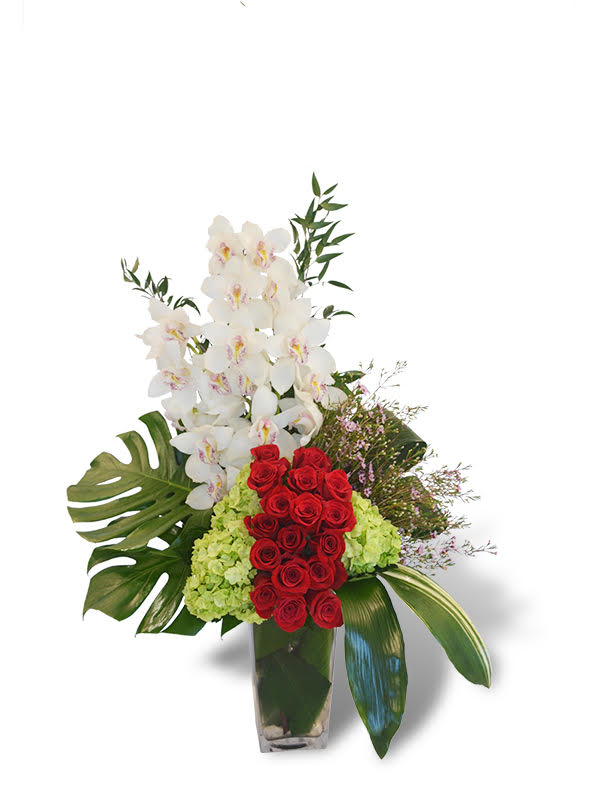 Elegant flower arrangement featuring red roses, white orchids, and lush greenery in a stylish vase.